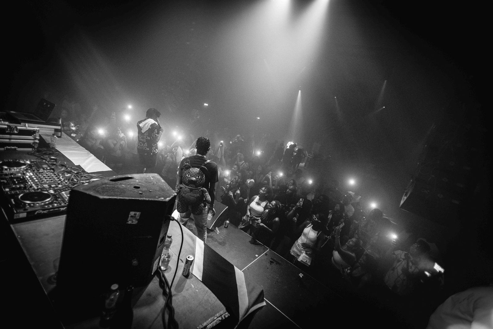 Concert stage view of a performer and crowd under spotlights